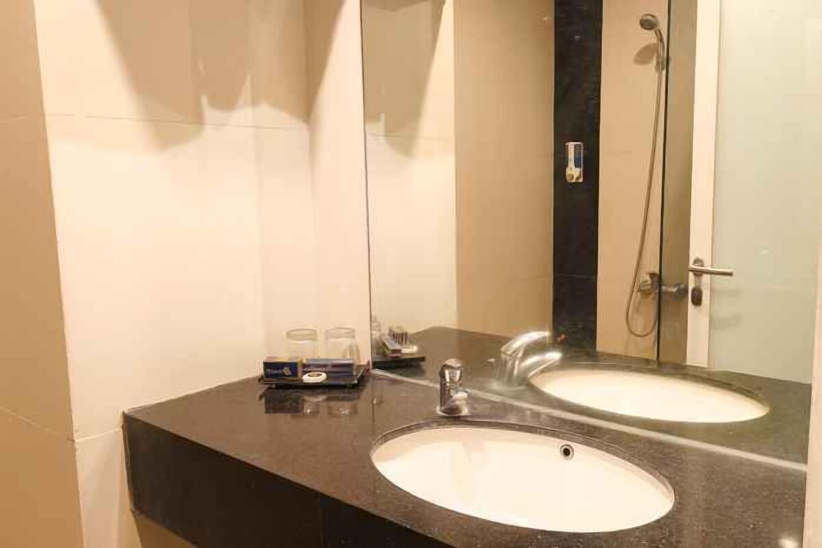A bathroom with two sinks, a mirror, and a shower.