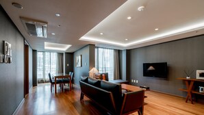 Una sala de estar moderna con un sofá, una mesa de comedor y un televisor.