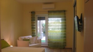 A bedroom with a bed, a sofa, a TV, and a window with curtains. - Demi's Home (Rome)