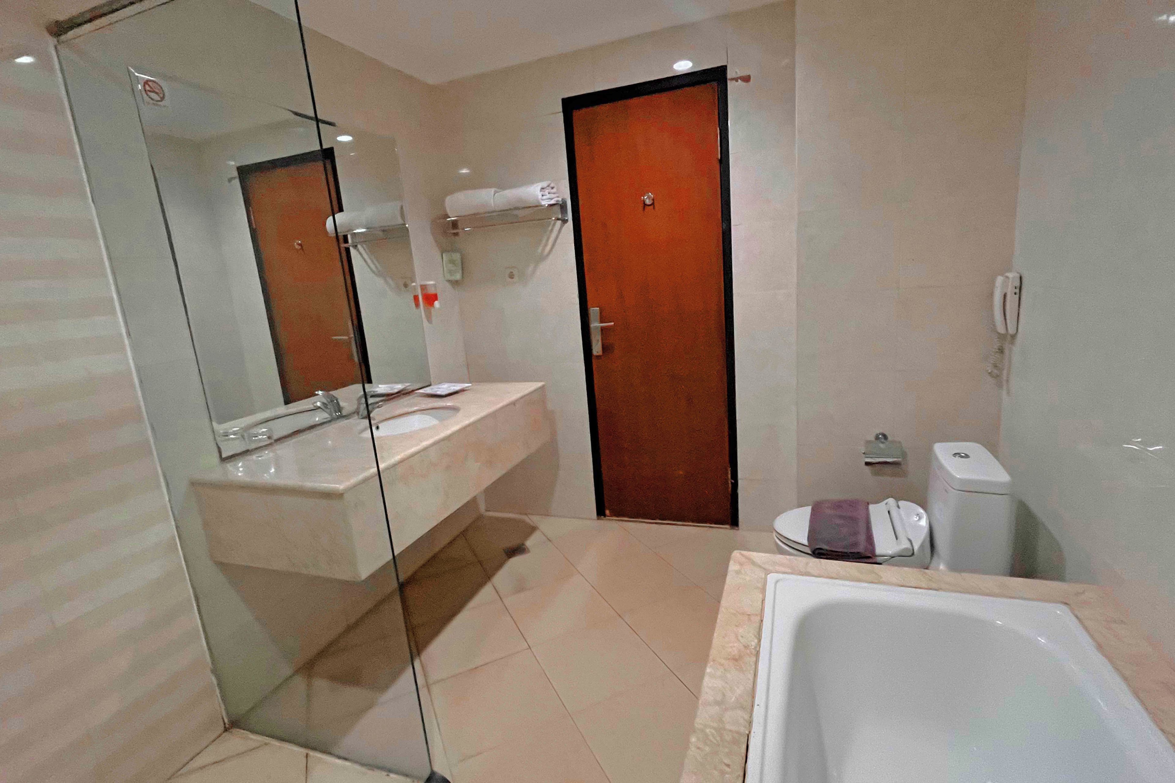A modern bathroom with a glass shower enclosure, a white sink, a toilet, and a bathtub.