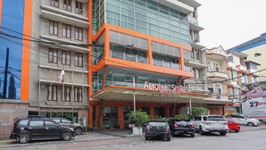 A hotel with a modern facade, multiple balconies, and a prominent entrance. - Aerotel Smile Makassar (Makassar)