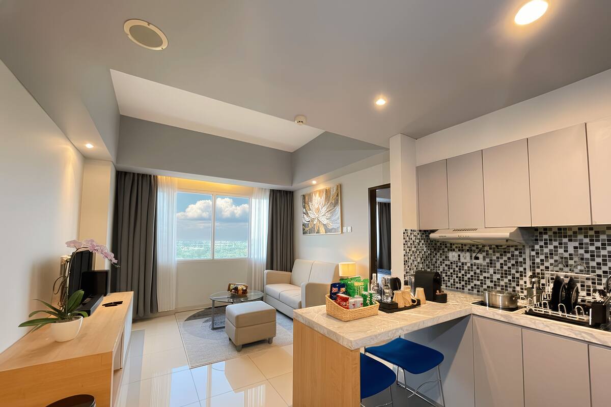 A modern apartment with a kitchen, living area, and a balcony with a city view.