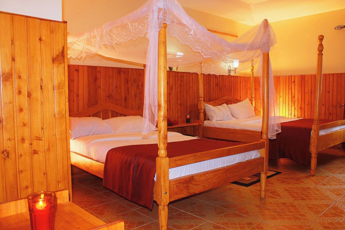 A four-poster bed with a canopy, wooden walls, and a tiled floor.