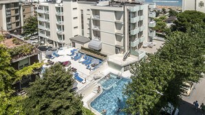 Ein Hotel mit Dachpool, mehreren Balkonen und Meerblick.