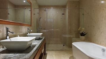 A modern bathroom with two sinks, a shower, and a bathtub.