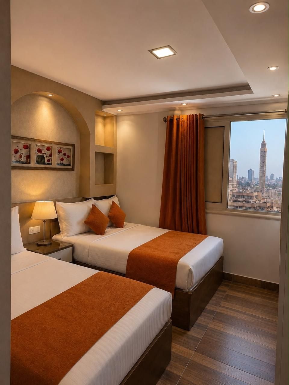 Une chambre d’hôtel avec deux lits, une vue sur la ville et un design moderne.