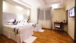 A hotel room with two beds, a desk, and a chair. - The Hotel 78 (Mandalay)