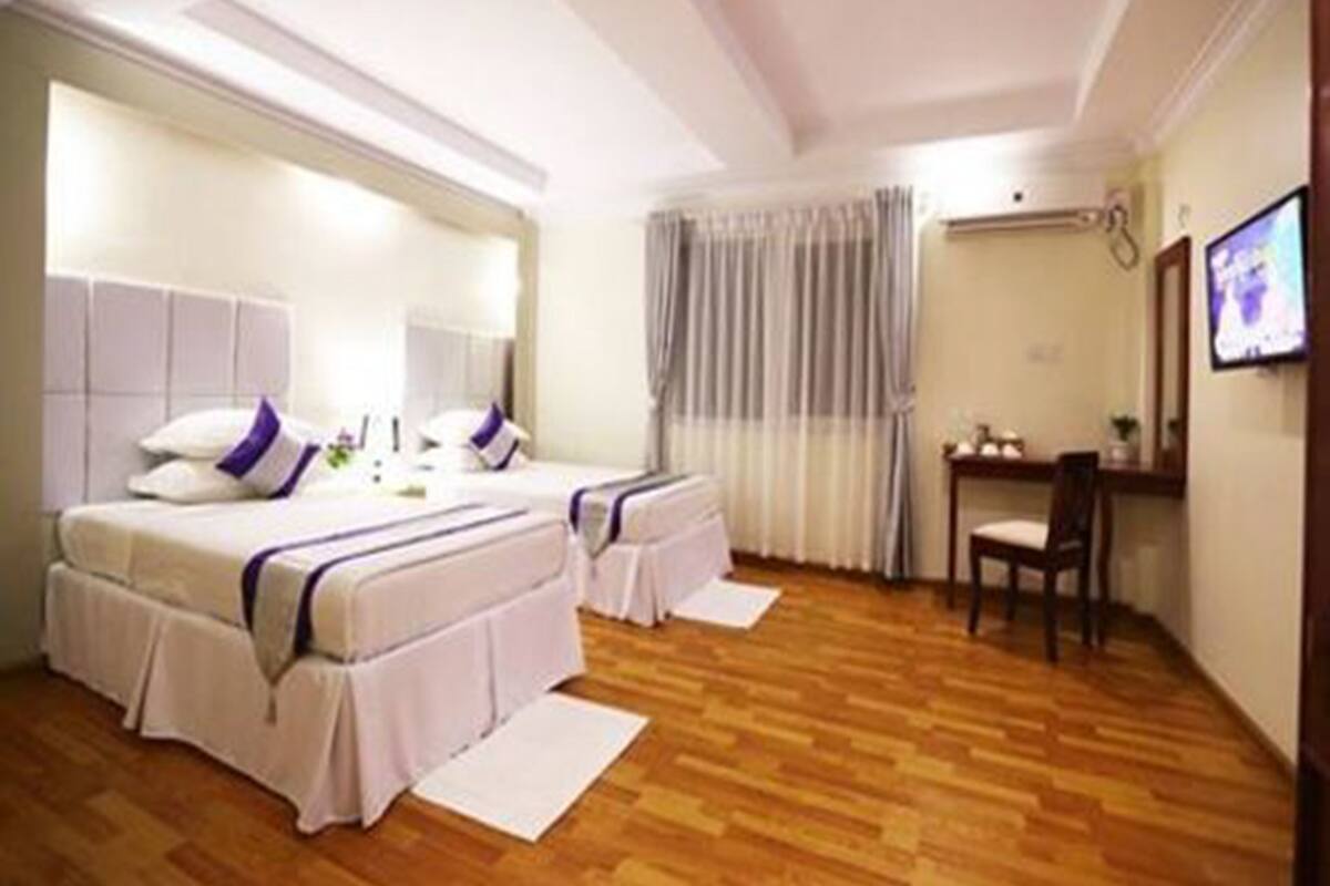 Una habitación de hotel con dos camas, un escritorio y una silla.