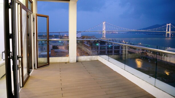 Een balkon met uitzicht op een brug en water.