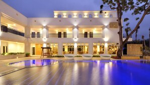 A modern hotel with a large outdoor swimming pool, multiple balconies, and well-lit interiors. - J Resort (Chishang)