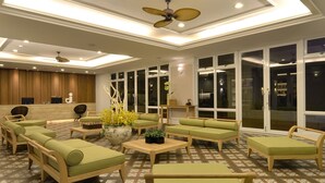 A spacious lobby with multiple seating areas, a reception desk, and large windows. - J Resort (Chishang)