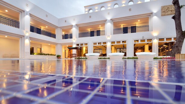 A spacious indoor pool area with multiple levels of balconies and a central seating area. - J Resort (Chishang)