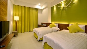 A hotel room with two beds, a TV, a bedside table, and a lamp. - J Resort (Chishang)