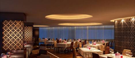 A restaurant with multiple tables, chairs, and decorative lighting fixtures.