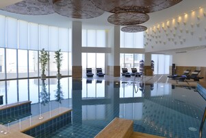 Una piscina cubierta, tumbonas, socorrista en las instalaciones