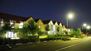 A row of modern, two-story houses with large windows and a well-lit street. - Farah Inn Ifrane (Ifrane)