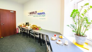 A conference room with a long table, chairs, a fire extinguisher, and a potted plant. - Mosaic Hotel (Riga)