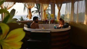 A couple in a jacuzzi with a view of the ocean. - Orabella Villas & Suites (Calangute)