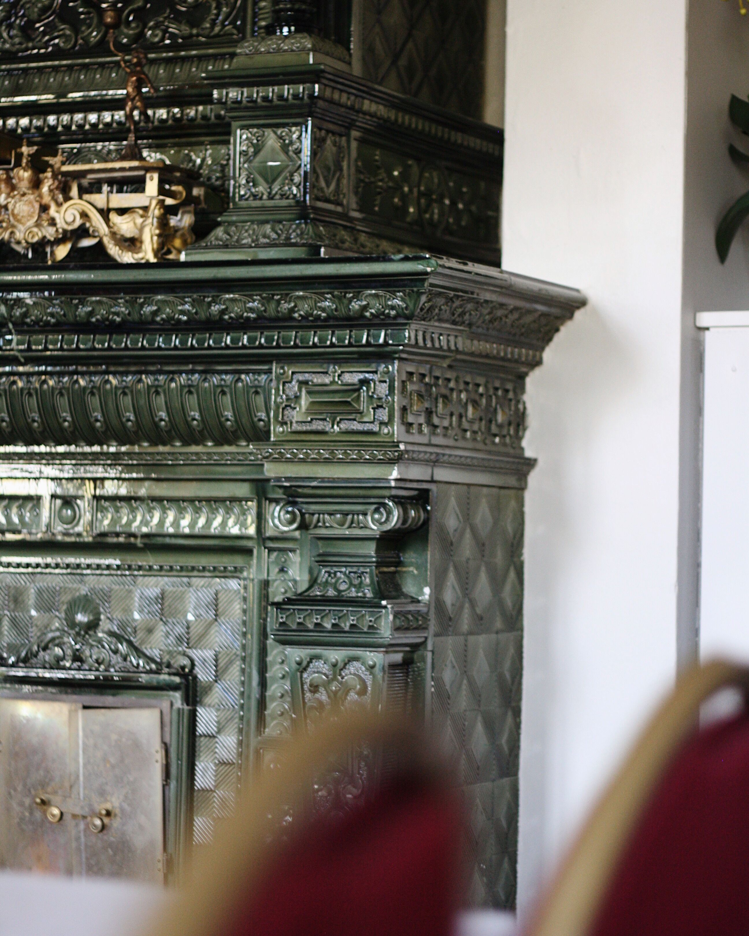 A detailed, ornate metal structure with intricate carvings and a decorative figure on top.