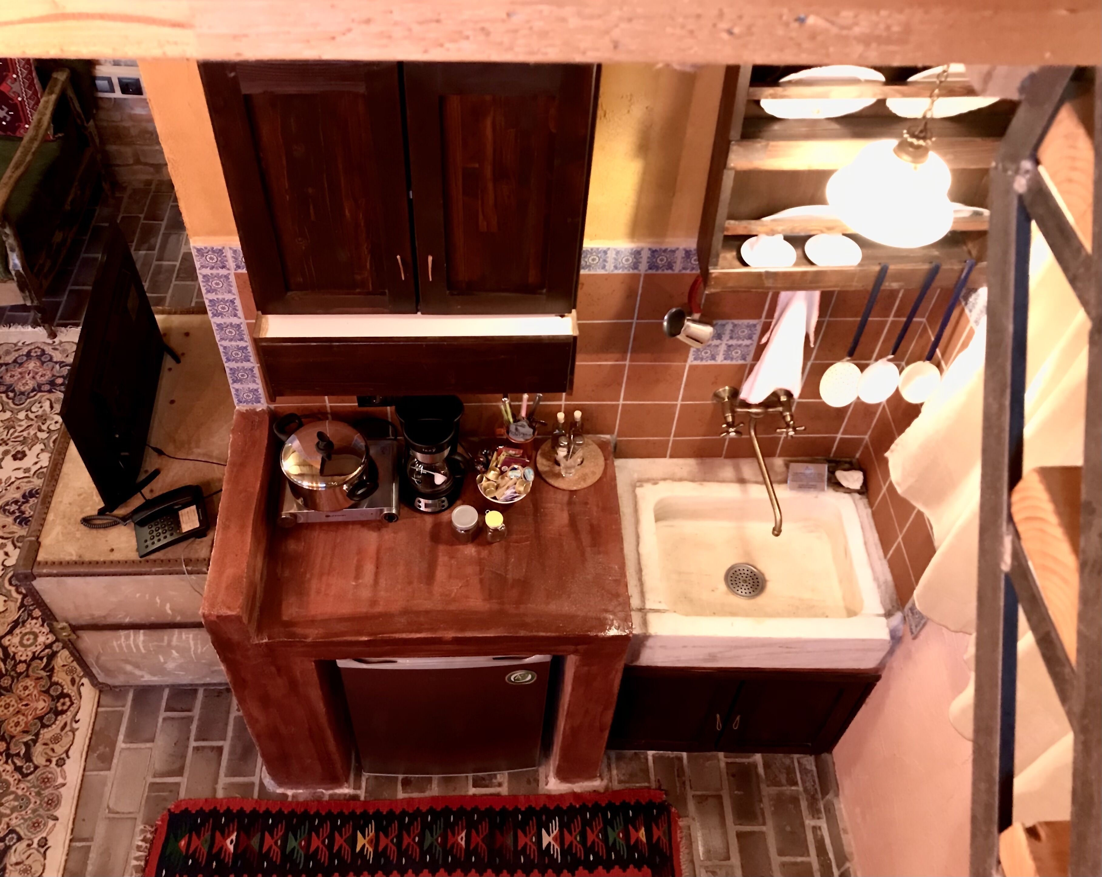 A compact kitchen with a sink, stove, and cabinets.