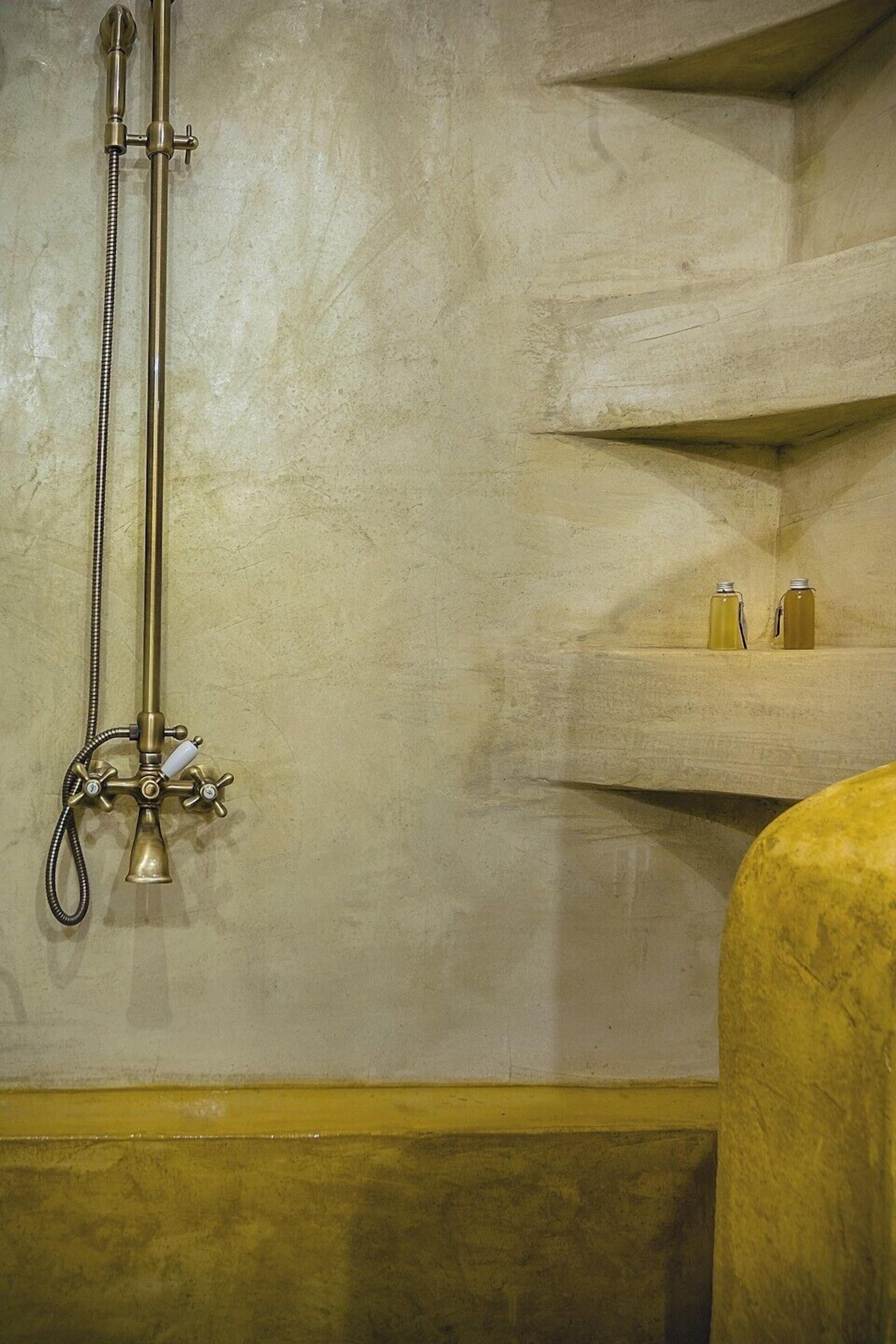 A bathroom with a shower, a bathtub, and a shelf with bottles.