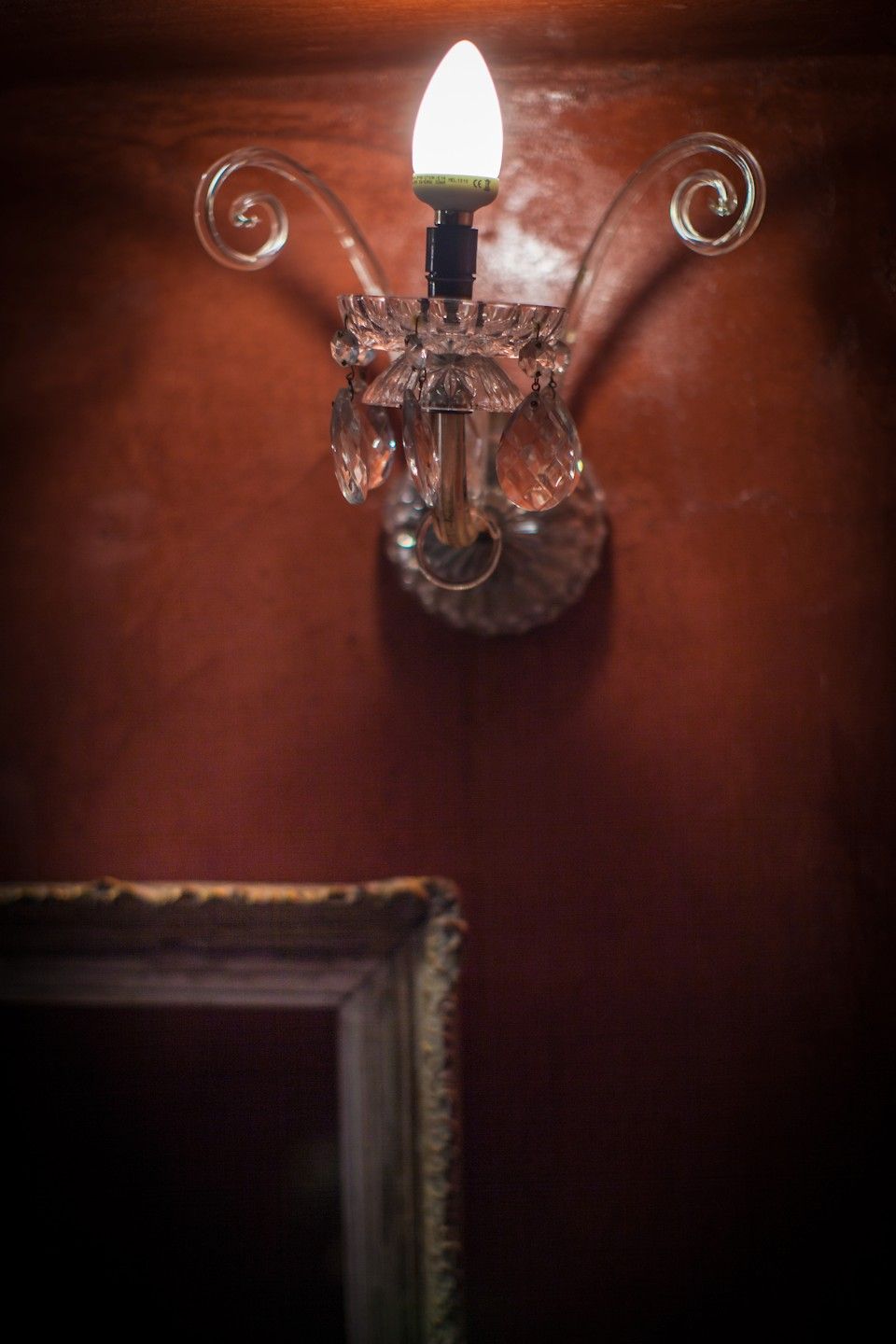 A wall-mounted light fixture with a clear glass shade and a visible bulb.