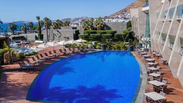 Una piscina cubierta, una piscina al aire libre de temporada, sombrillas