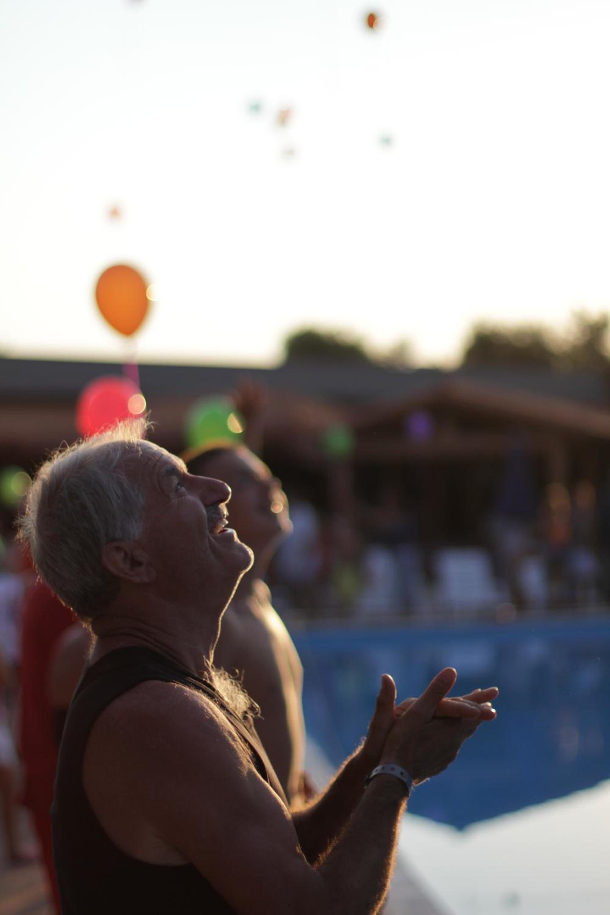 Una persona in piedi accanto a una piscina, sullo sfondo sfocato.