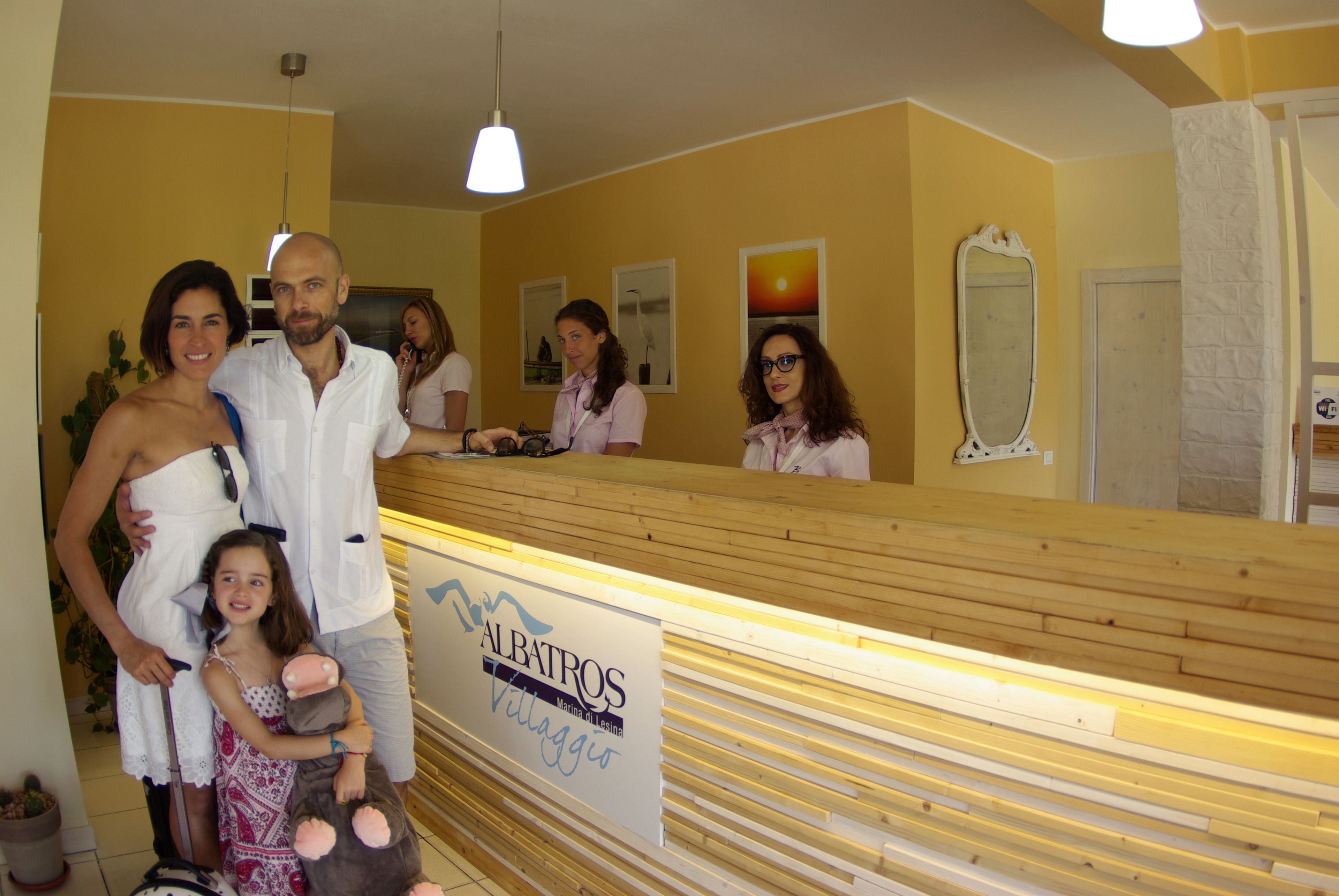 A reception desk with a sign reading "ALBATROS Village".