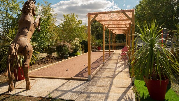 A wooden pergola with a tiled floor leading to a covered seating area. - Hotel Mac Bed (Poitiers)