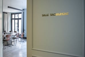 A conference room with a table and chairs, a large window, and a sign reading 'SALLE BACHAUMONT'. - Hotel Bachaumont (Paris)