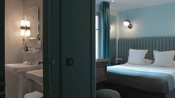 Ett hotellrum med badrum som har handfat, spegel och hygienartiklar. Rummet har en säng med sänggavel, kuddar och ett nattduksbord med en lampa.