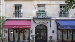 A hotel facade with a prominent entrance, balconies with plants, and two adjacent bars named "Le Bar Chaumont" and "Lieu de Vie". - Hotel Bachaumont (Paris)