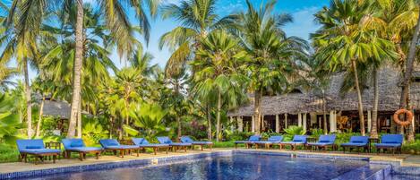 Een binnenzwembad, een buitenzwembad en parasols bij het zwembad