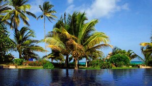 A poolside view with palm trees and a clear sky. - The Palms Zanzibar - All Inclusive (Dongwe)