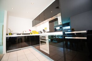 Apartamento superior, 2 quartos (KT) | Cozinha privada | Geladeira grande, micro-ondas (mediante solicitação), cooktop