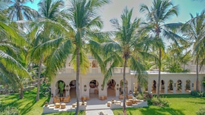 Un resort con patio, palmeras y zonas de estar al aire libre.