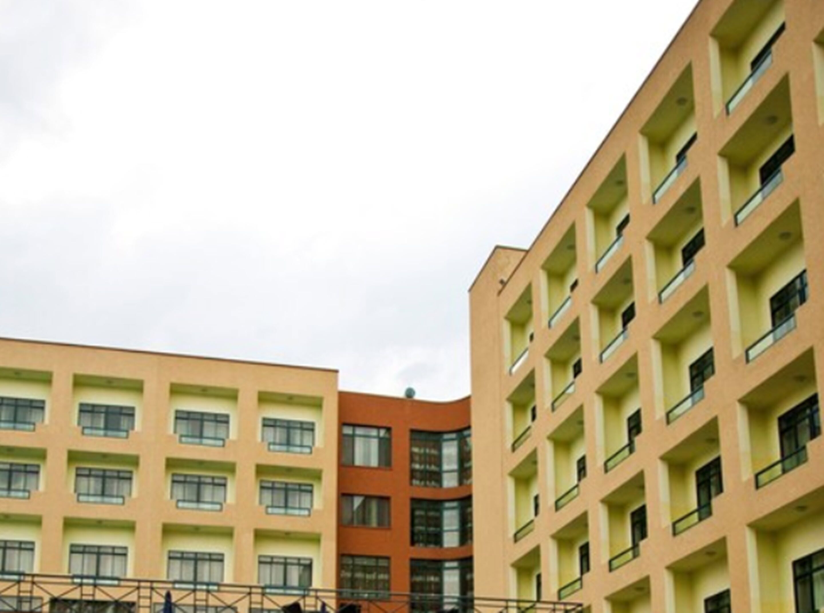 A multi-story building with a consistent architectural style, featuring balconies and a uniform window pattern.
