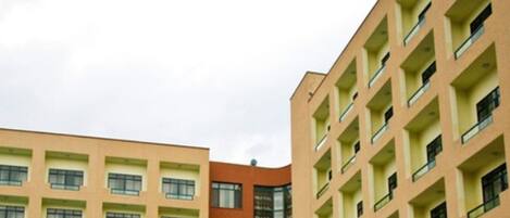 A multi-story building with a consistent architectural style, featuring balconies and a uniform window pattern.