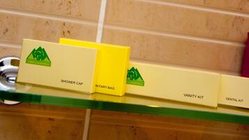 A bathroom shelf with toiletries including a shower cap, a Nitaray bag, a vanity kit, and a dental kit.