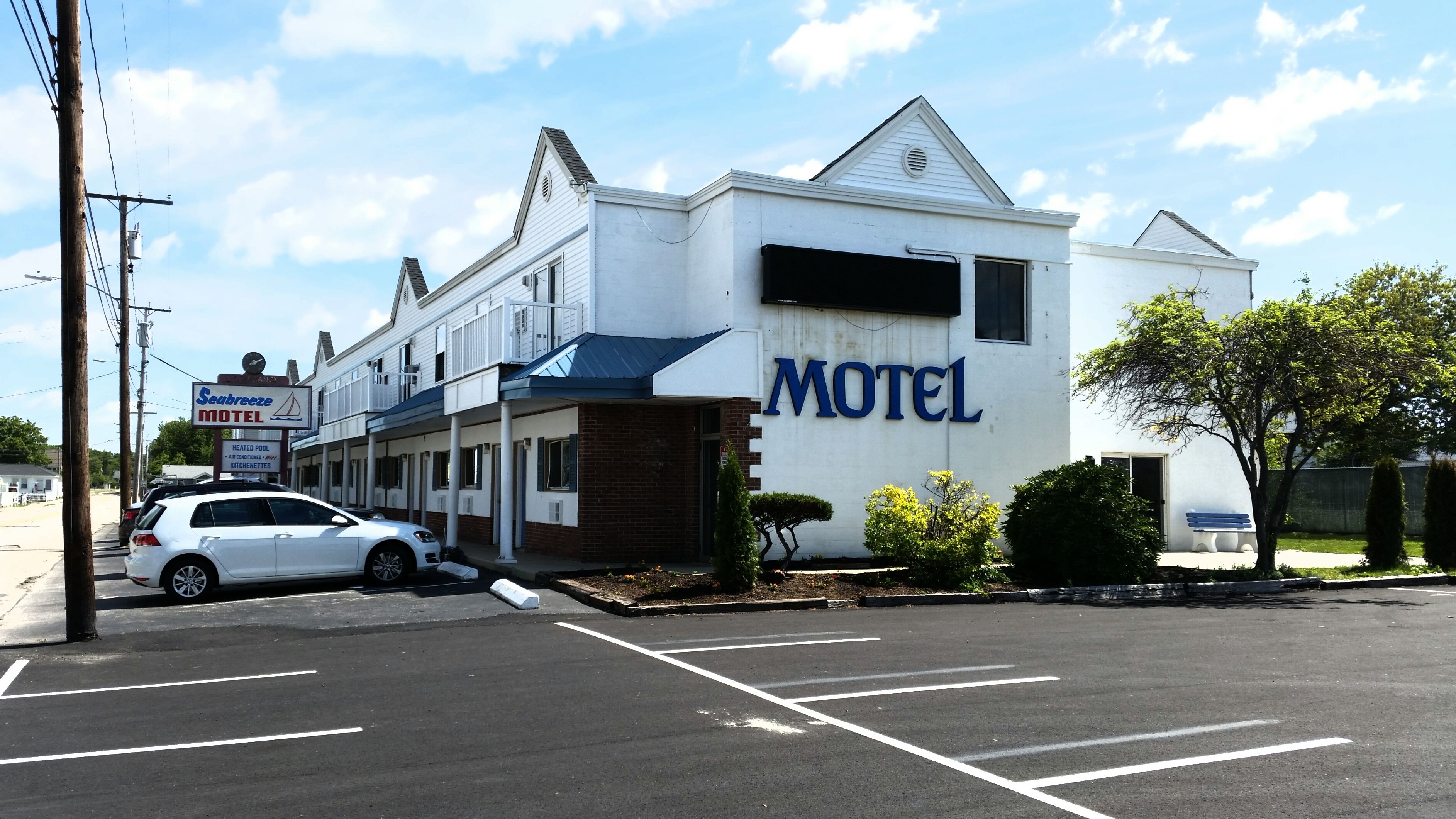 A motel with a large sign reading "Motel" and a smaller sign for "Seabreeze Motel" with amenities listed.