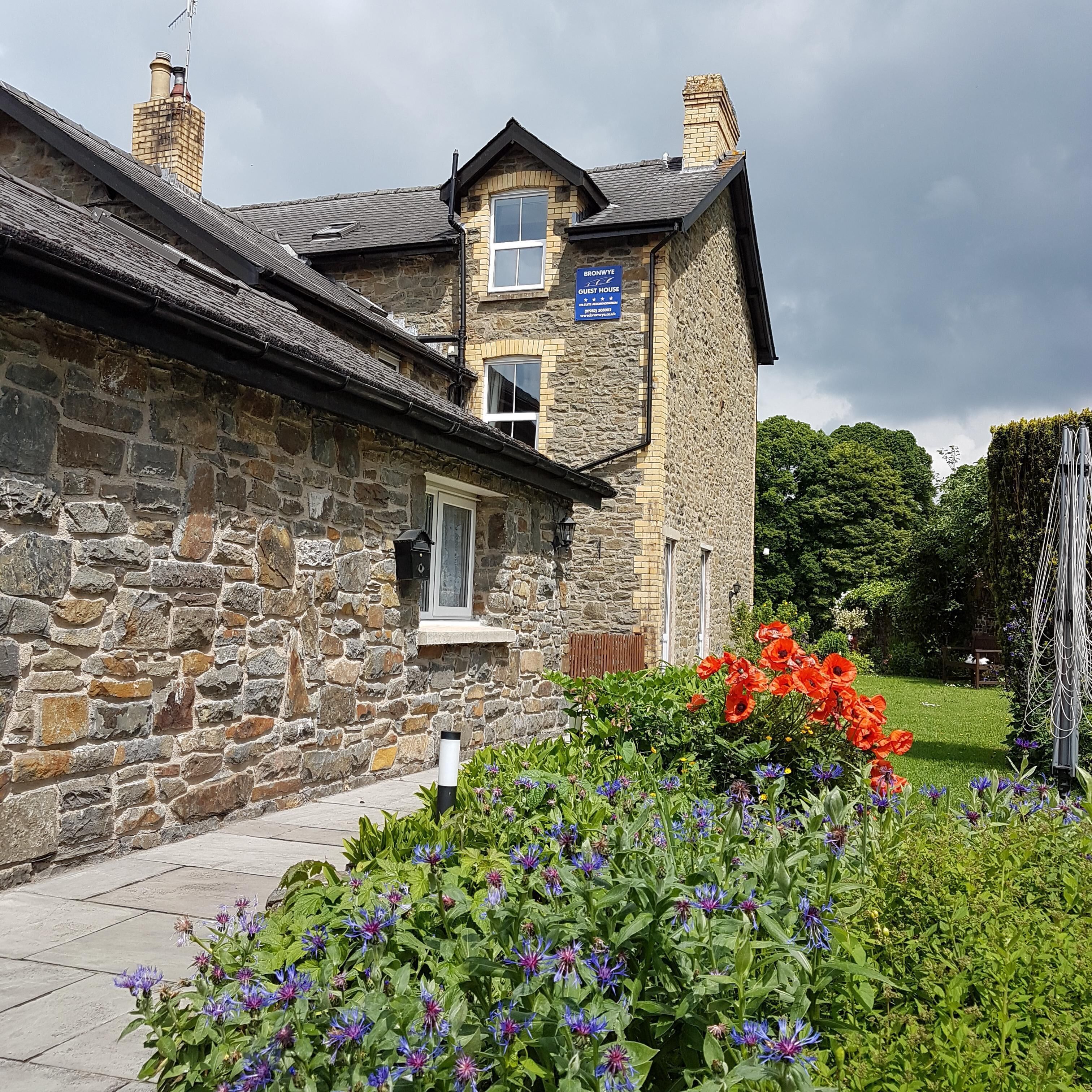 A stone building with a sign indicating it is a guest house.