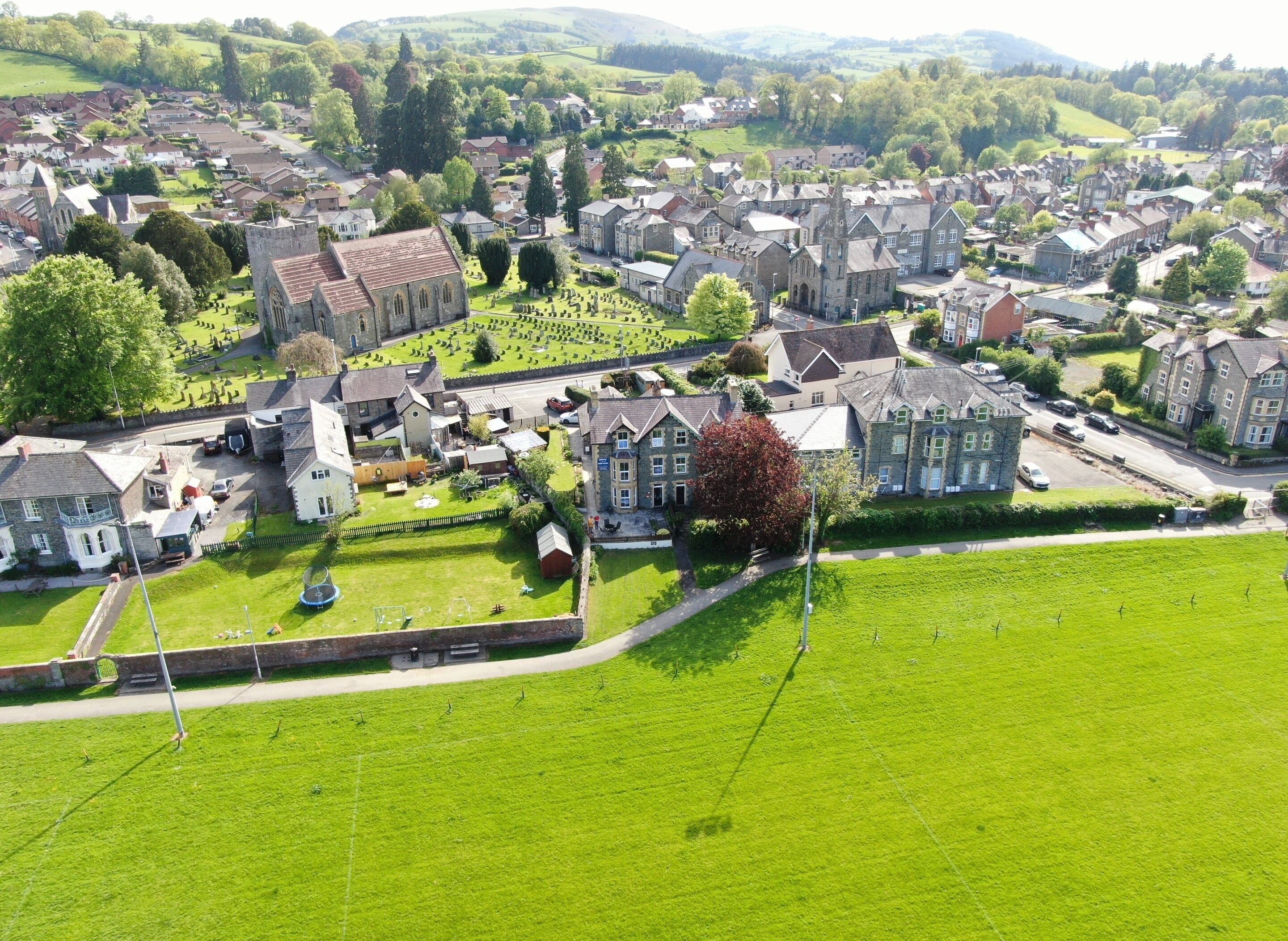 An aerial view of a town with historic buildings, a church, and a cemetery.
