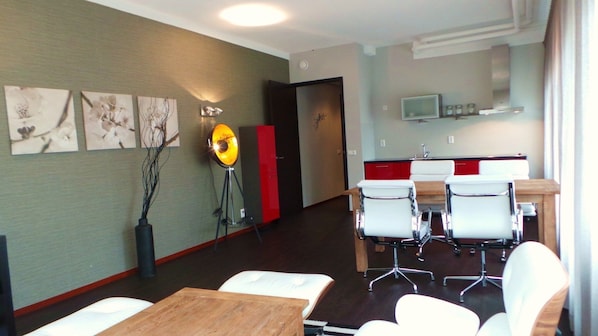 Moderni hotellihuone, jossa on ruokailutila, keittiö ja käytävä.