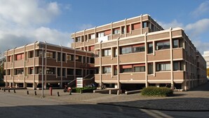 Un edificio de varios pisos con un diseño arquitectónico moderno, que combina ladrillo y concreto.