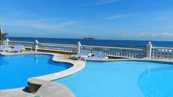 Una piscina al aire libre, sombrillas