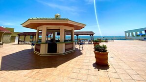 A covered outdoor area with a gazebo, lounge chairs, and a pool. - Hotel Villa Florida Veracruz (Boca del Río)