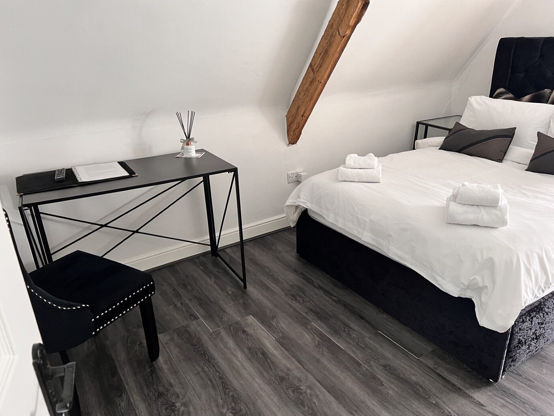 Ein modernes Schlafzimmer mit Bett, Nachttischen, Schreibtisch und Stuhl.
