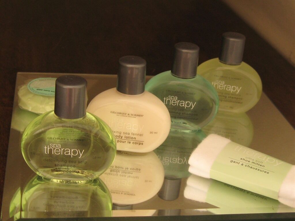 Presentación de productos para terapias de spa, incluyendo loción corporal, champú y jabón de baño.