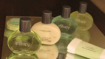 Presentación de productos para terapias de spa, incluyendo loción corporal, champú y jabón de baño.